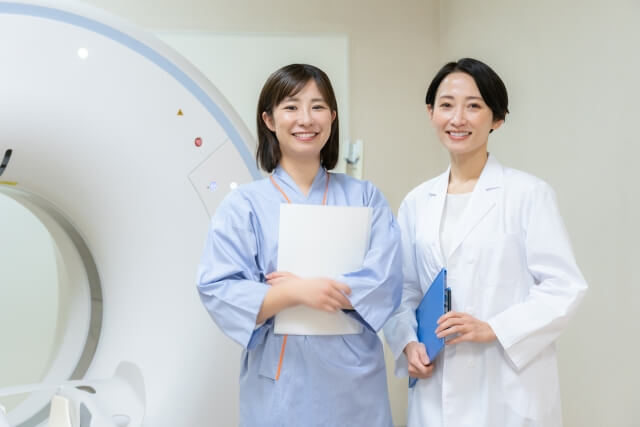 MRIの前でほほえむ医者と患者