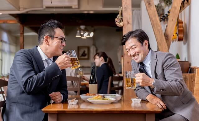 居酒屋でビールを飲む二人のサラリーマン
