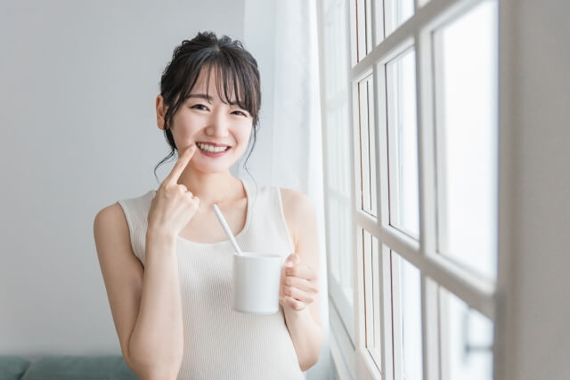 歯ブラシセットを持って笑う女性