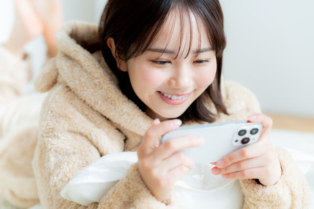 スマートフォンで動画を見ている女性