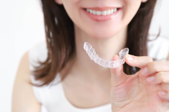 マウスピースを手に持つ女性