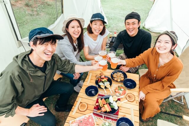 キャンプで乾杯する5名の男女