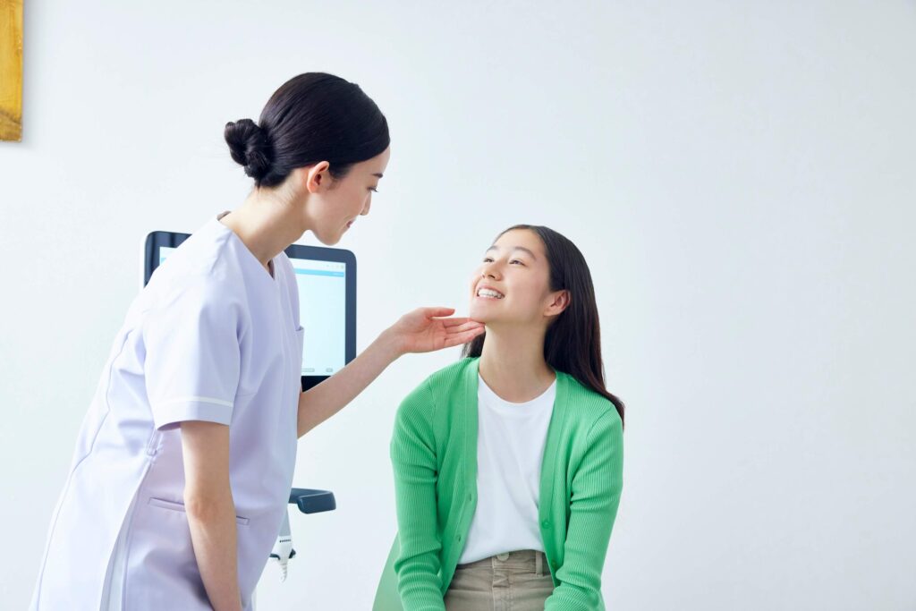 歯科医師に口腔内を診てもらう女子高生