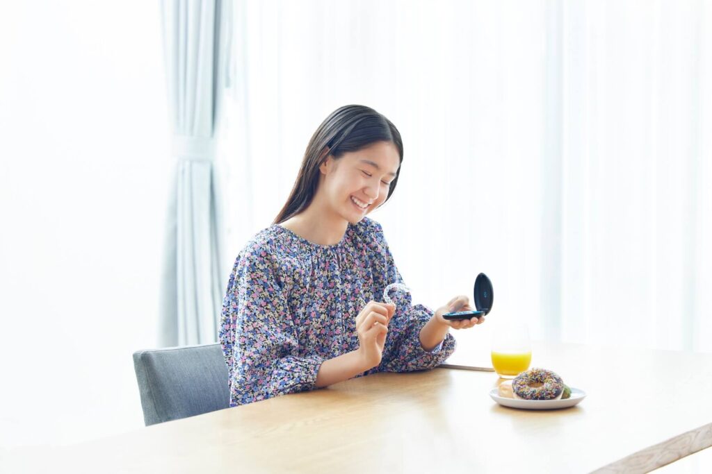 インビザラインのアライナーを外す女子高生