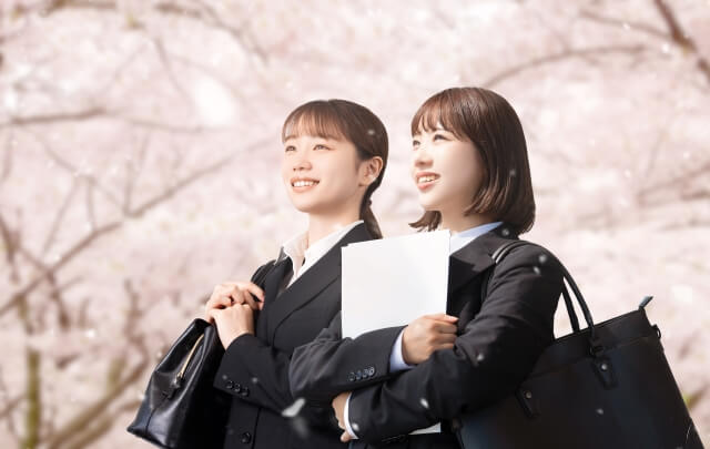 桜の木の下で微笑む新入社員