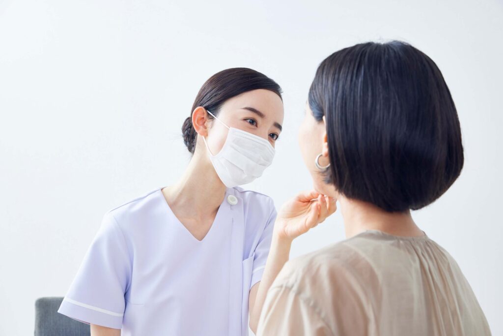 患者さんの口腔内を確認する歯科医師