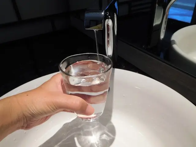 洗面所でコップに水を注ぐ