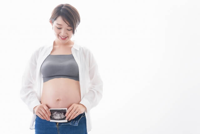 エコー写真を持つ妊婦